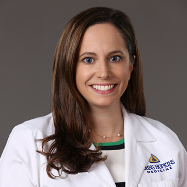 Surgical oncologist Kelly Lafaro, in a formal portrait, wearing a white lab coat.